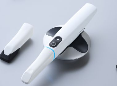 Aufnahme von dem TRIOS5 Intraoralscanner auf einem Tisch und daneben verschiedene Werkzeuge